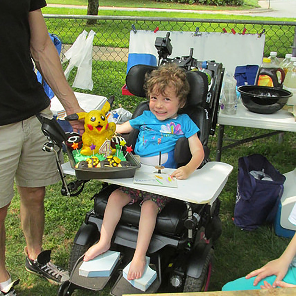 Bennett smiling with a Pikachu birthday cake