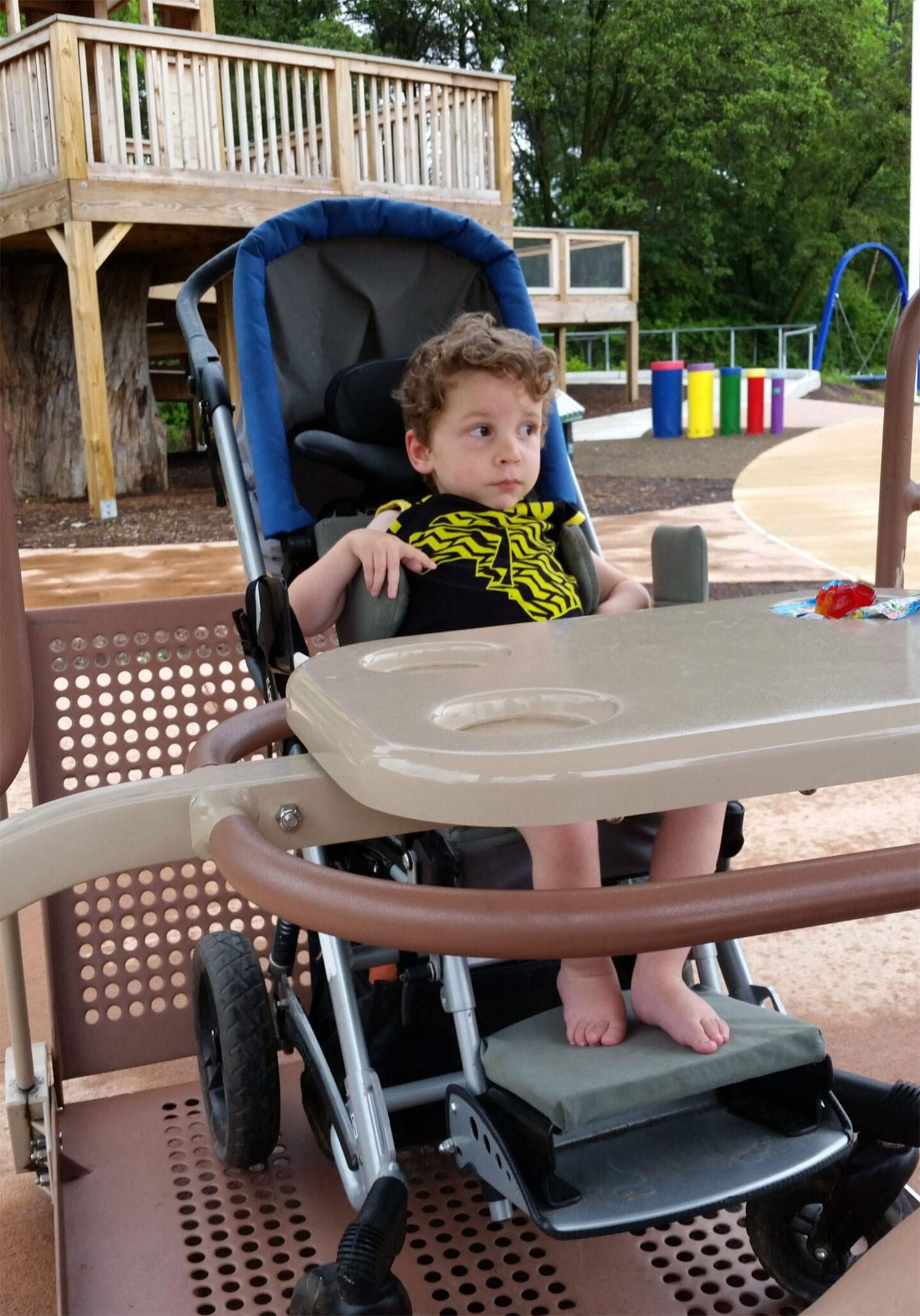Bennett in a stroller on an accessible swing